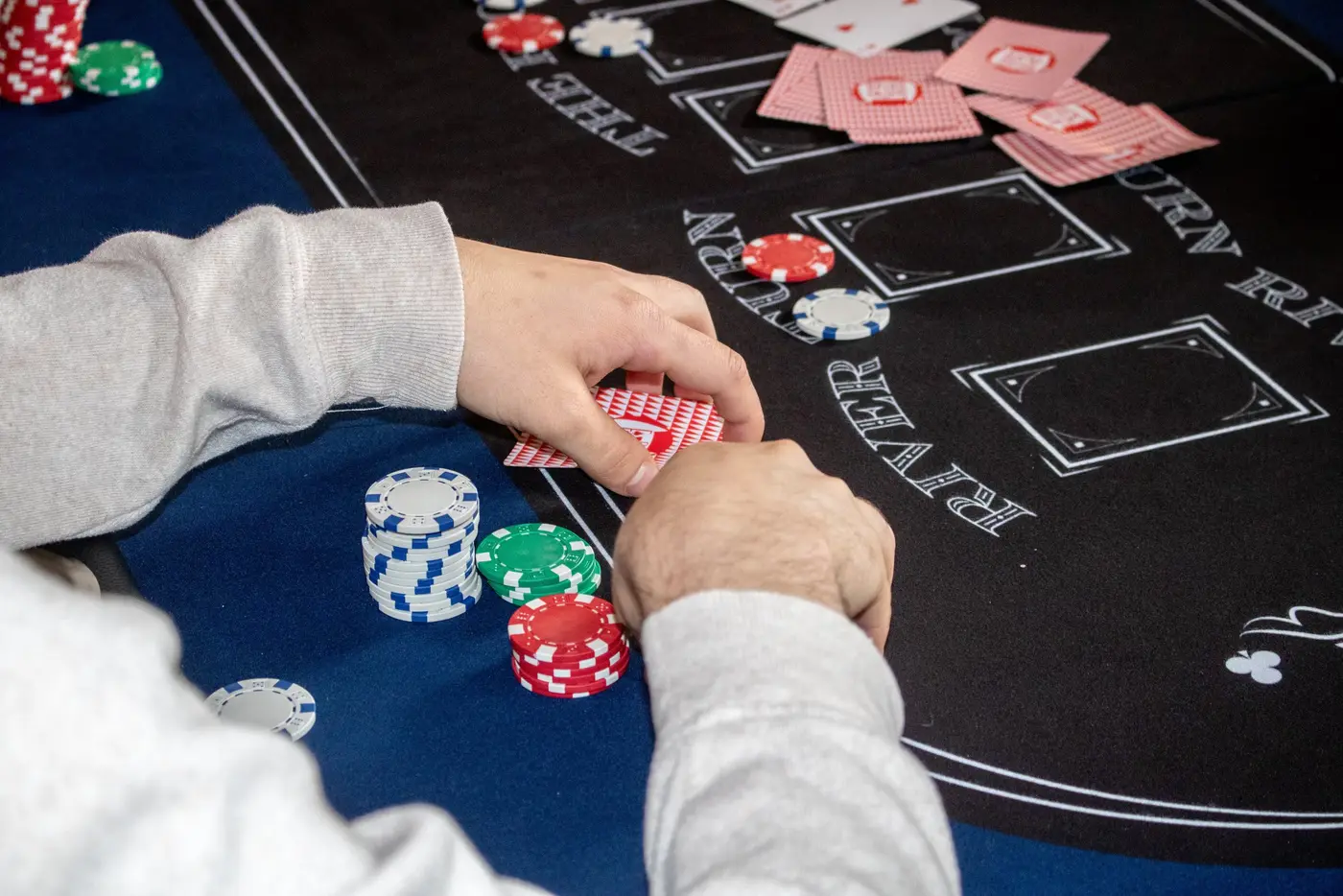 A player stacks chips on the club's printed felt